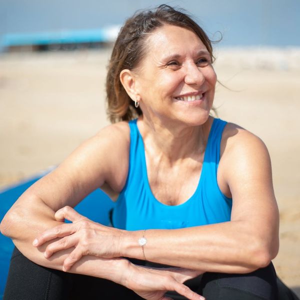 Person smiling peacefully outdoors after a light exercise session.